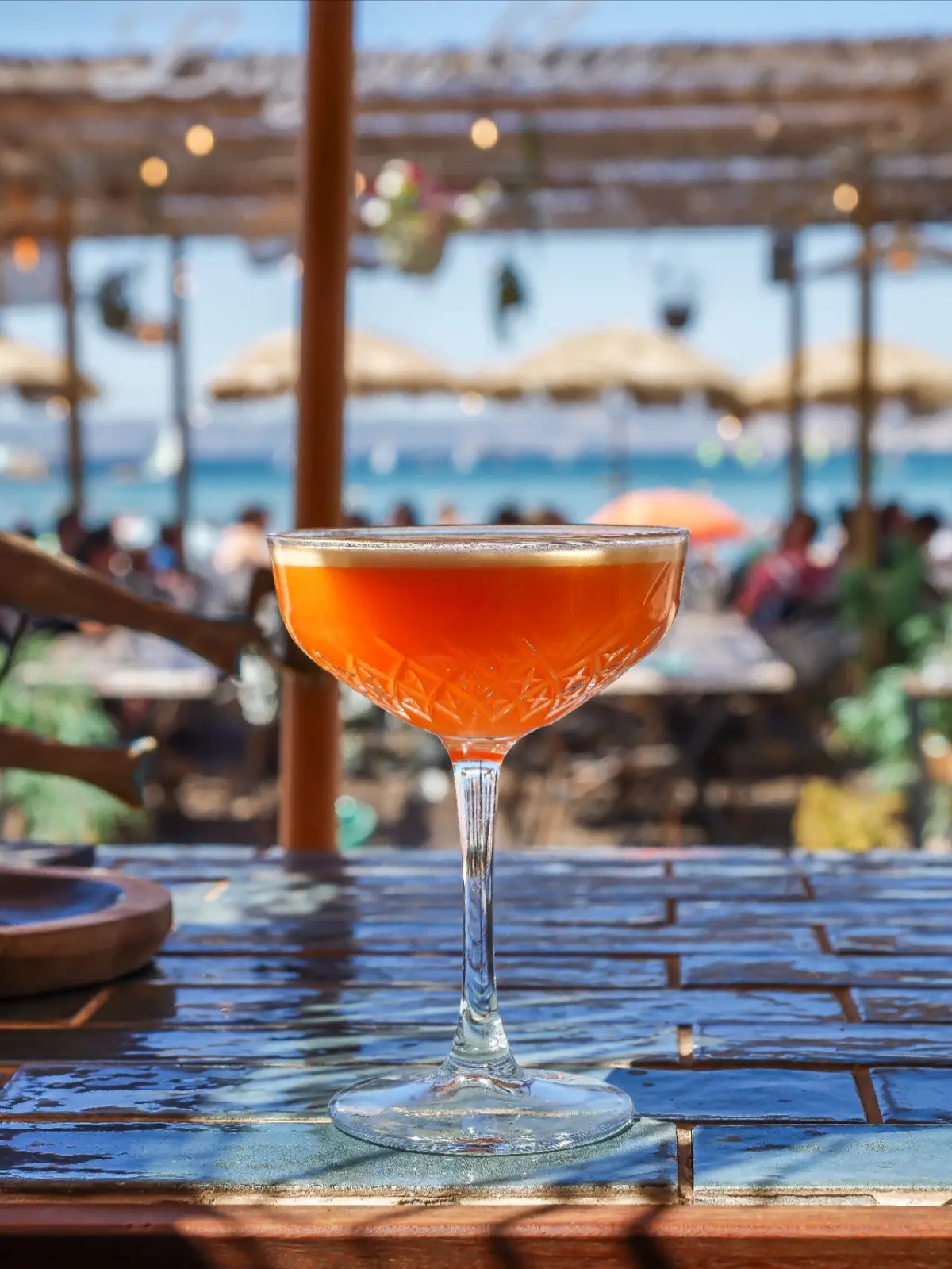 Cocktail orange en coupe travaillée face à la mer