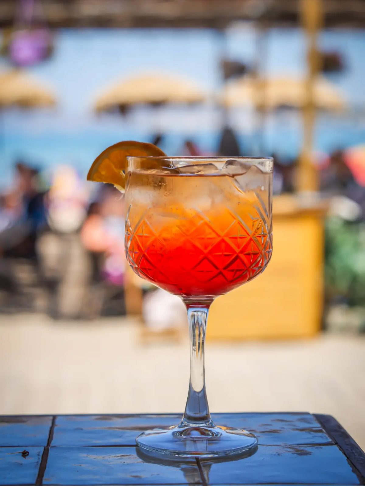 Cocktail rouge en coupe travaillée face à la mer