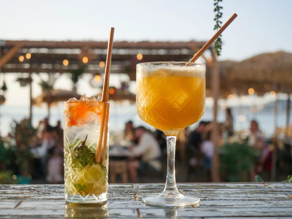 Deux cocktails posés sur une table au coucher du soleil