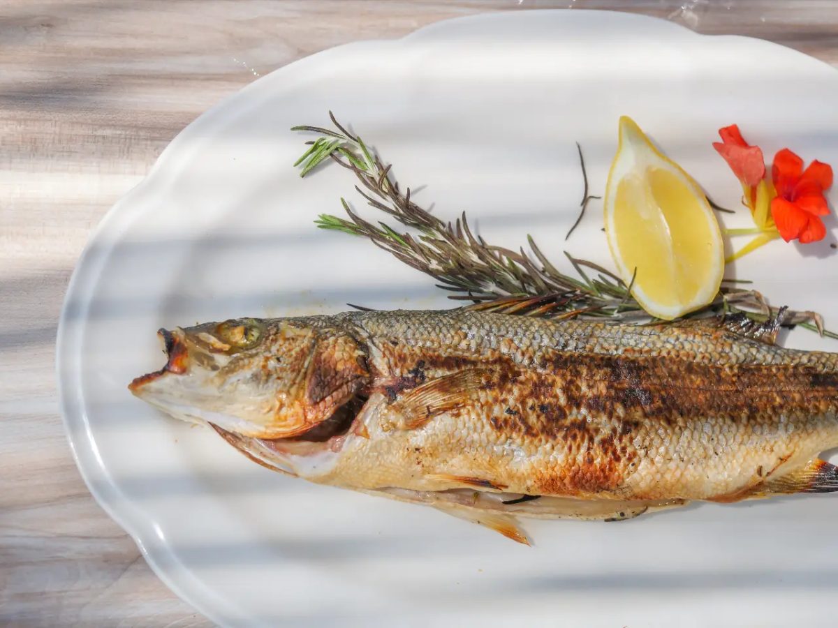 Daurade royale grillée présentée avec citron et romarin
