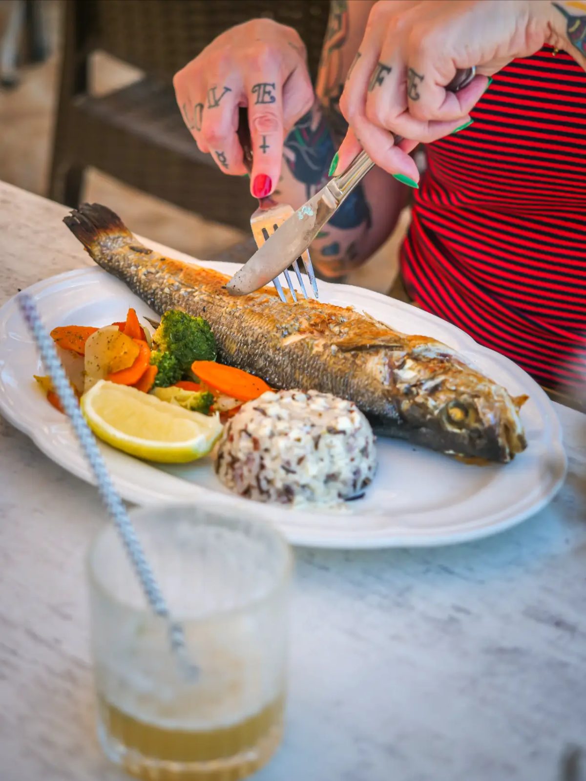 Loup entier servi avec riz sauvage et légumes