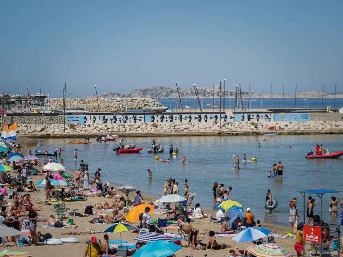Plage de la Pointe Rouge bondée avec port en arrière-plan