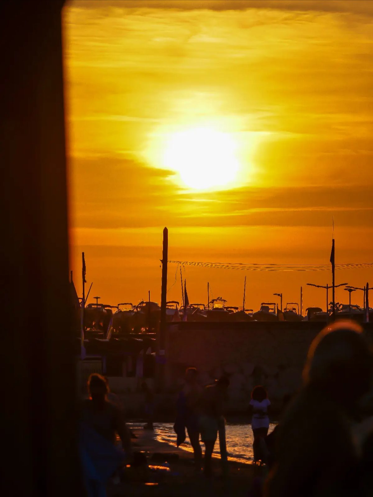 Coucher de soleil orange sur le port avec mâts de bateaux